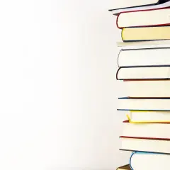 Stos kolorowych książek na białym tle.