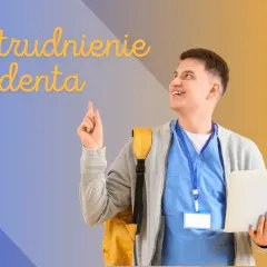 Uśmiechnięty student z plecakiem i laptopem wskazuje palcem w górę.